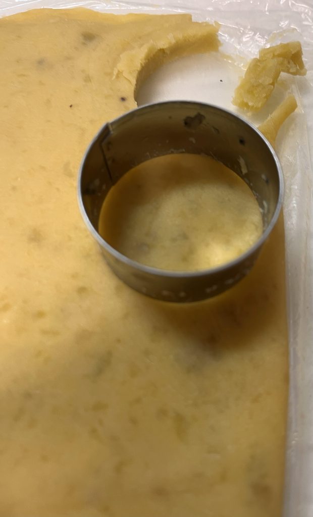 冷凍したスイートポテトを、クッキー生地と同じ丸型で抜いているところ