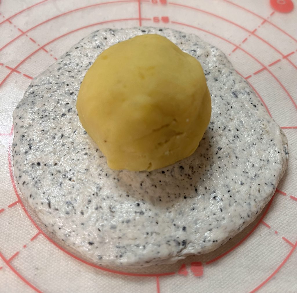 黒ごまの生地のまんなかに、丸めたスイートポテトをのせたところ